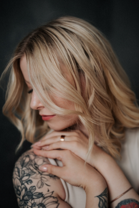 Modernes Headshot einer Frau mit Tattoos und natürlichem Ausdruck im Studio in Salzburg